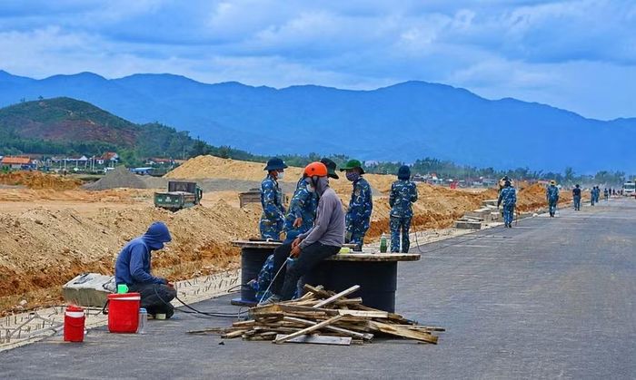 Công nhân lắp đặt hệ thống cáp điện và thiết bị điều khiển bay tại đường cất hạ cánh số 2 Cảng hàng không Phù Cát. Ảnh: Hải Yến