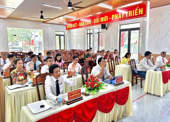 Các đại biểu HĐND xã biểu quyết thông qua nghị quyết.