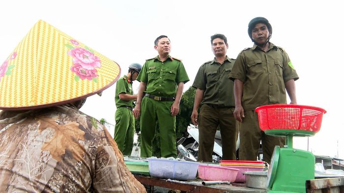 Anh Huỳnh Sẽ (đứng đầu, đội mũ bảo hiểm) cùng lực lượng Công an xã tuyên truyền, vận động Nhân dân không buôn bán lấn chiếm lòng, lề đường