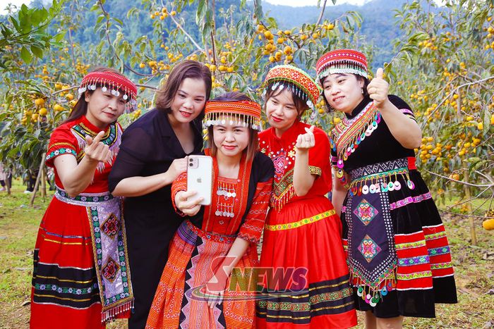 Du khách trong bộ trang phục dân tộc chụp ảnh tại vườn hồng.