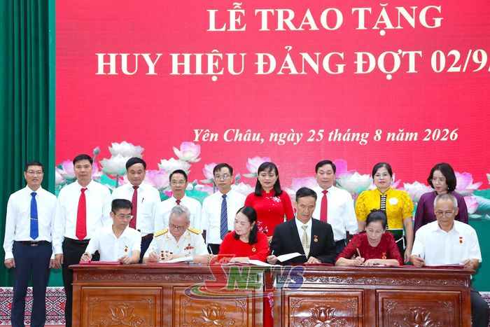 Đại biểu chứng kiến các đảng viên ký nhận vào sổ tặng Huy hiệu Đảng của Đảng bộ xã.