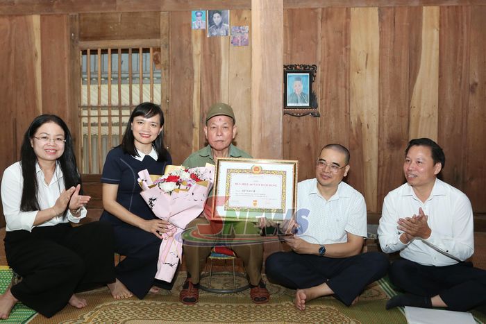 Đồng chí Lường Thị Vân Anh trao Huy hiệu 60 năm tuổi Đảng cho đảng viên Lừ Văn Sé, Chi bộ bản Suối Phà, Đảng bộ xã Chiềng Hặc.