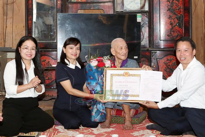 Đồng chí Lường Thị Vân Anh trao Huy hiệu 60 năm tuổi Đảng cho đảng viên Lò Văn Viến, Chi bộ bản Nà Ngà, Đảng bộ xã Chiềng Hặc.