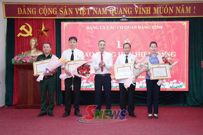 Đồng chí Phó Bí thư Đảng ủy các cơ quan Đảng tỉnh trao Huy hiệu 30 năm tuổi Đảng cho các đảng viên.