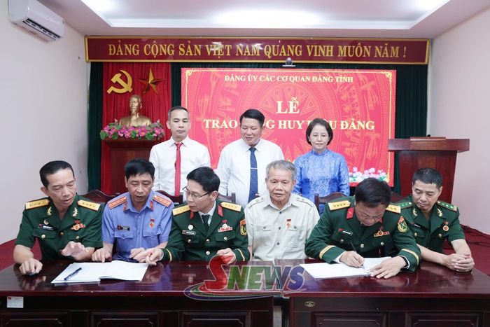 Các đảng viên ký vào sổ tặng Huy hiệu Đảng của chi bộ.