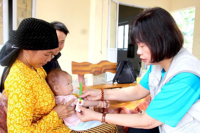 Chuyên gia tổ chức UNICEF đo vòng cánh tay đánh giá tình trạng suy dinh dưỡng của trẻ tại điểm Trạm Y tế Ngọc Linh, xã Linh Hồ.