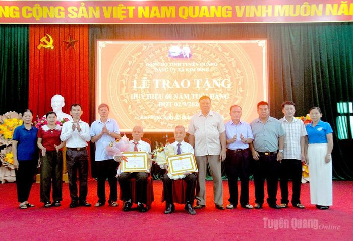 Các đồng chí trong Ban Thường vụ Đảng ủy xã Kim Bình tặng hoa chúc mừng các đảng viên được nhận Huy hiệu Đảng.