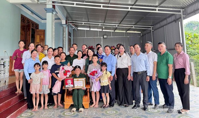 Phó Trưởng đoàn ĐBQH chuyên trách tỉnh Lý Thị Lan trao Huy hiệu 65 năm tuổi Đảng và chụp ảnh lưu niệm cùng đảng viên Lý Văn Hoa, Chi bộ thôn Phúc Ninh, xã Xuân Vân.