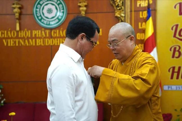 Trưởng lão Hòa thượng Thích Thanh Nhiễu cài hoa hồng Vu lan đến Bộ trưởng Bộ Dân tộc và Tôn giáo nhân chuyến thăm