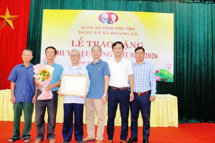 Đồng chí Nguyễn Tiến Thịnh chụp ảnh lưu niệm cùng con, cháu nhân dịp đón nhận Huy hiệu 65 năm tuổi Đảng, tổ chức ngày 25/8/2026 tại Hội trường Đảng ủy xã Hoàng An, tỉnh Phú Thọ. Ảnh: Quỳnh Hương