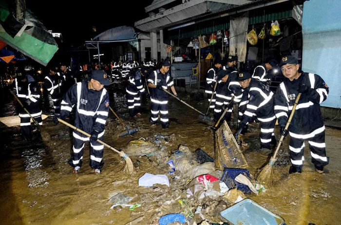 Công an tỉnh Lạng Sơn dọn dẹp bùn đất, rác tại chợ Giếng Vuông trong đêm ngày 24/8. Ảnh: Công an tỉnh Lạng Sơn
