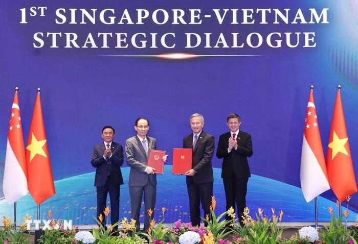 Bộ trưởng Ngoại giao Lê Hoài Trung và Bộ trưởng Ngoại giao Singapore Vivian Balakrishnan trao Bản ghi nhớ hợp tác giữa hai Đảng. Ảnh: TTXVN