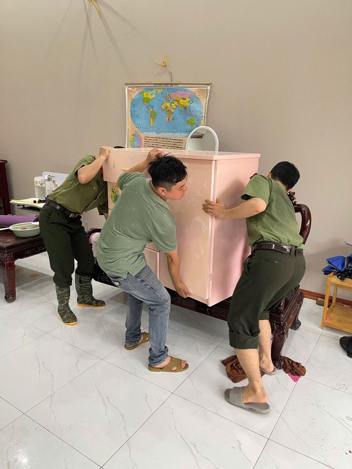 Cán bộ, chiến sĩ Công an giúp dân kê đồ dùng, vật dụng sinh hoạt để ổn định cuộc sống sau lũ rút.