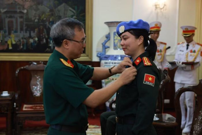 Trung tá Đoàn Thị Thanh Nga, Tổ trưởng Tổ công tác số 9 vinh dự được trao Huy hiệu Bác Hồ.