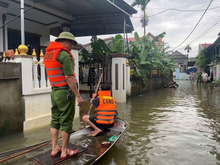Công an xã Triệu Sơn hỗ trợ người dân ứng phó với tình trạng ngập úng.