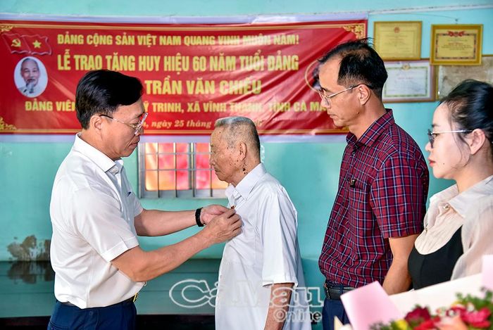 Đồng chí Huỳnh Hữu Trí, Chủ nhiệm Uỷ ban Kiểm tra Tỉnh uỷ, trao Huy hiệu 60 năm tuổi Đảng cho đồng chí Trần Văn Chiếu.