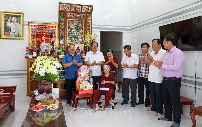 Phó Bí thư Thường trực Tỉnh uỷ Huỳnh Quốc Việt (thứ hai từ trái sang) cùng đoàn công tác chụp ảnh lưu niệm với Anh hùng Lực lượng vũ trang nhân dân Phạm Thị Bay, ấp Rau Dừa B, xã Hưng Mỹ.