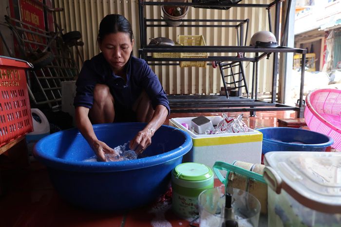 Gia đình chị Huyên bắt tay dọn dẹp ngay sau khi lũ rút để vớt vát hàng hóa.