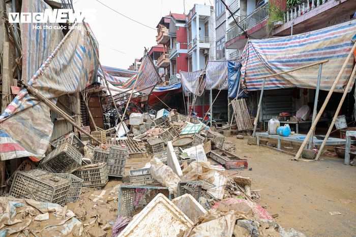 Rác thải, bùn đất và đồ đạc hư hỏng sau lũ chất thành từng đống trước cửa nhà, chờ được thu gom, xử lý.