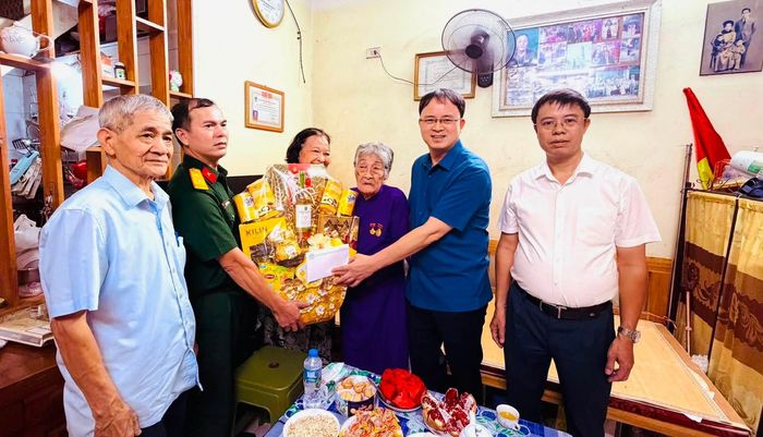 Đoàn công tác phường Vĩnh Tuy trao quà, thể hiện sự tri ân đối với cụ Lã Thị Tơ, cán bộ cách mạng bị địch bắt, tù đày. Ảnh: PV