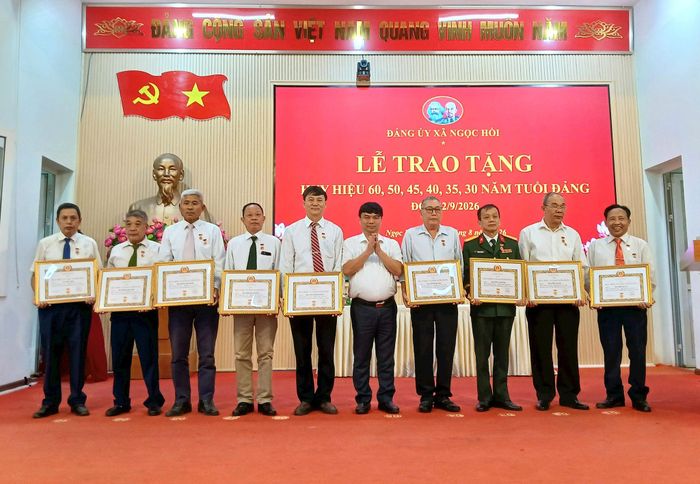 Chủ tịch UBND xã Ngọc Hồi Trần Việt Trung trao Huy hiệu Đảng cho các đảng viên. Ảnh: Hoàng Quyết