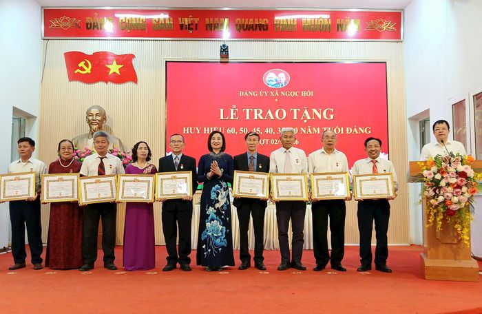 Phó Bí thư Thường trực Đảng ủy xã Ngọc Hồi Nguyễn Thị Hằng trao Huy hiệu Đảng cho các đảng viên. Ảnh: Hoàng Quyết