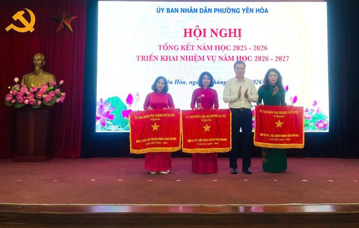 Bí thư Đảng ủy, Chủ tịch HĐND phường Yên Hòa Nguyễn Quốc Khánh trao cờ thi đua của thành phố tặng 3 tập thể trường học có thành tích xuất sắc trong phong trào thi đua năm học 2025-2026. Ảnh: PV