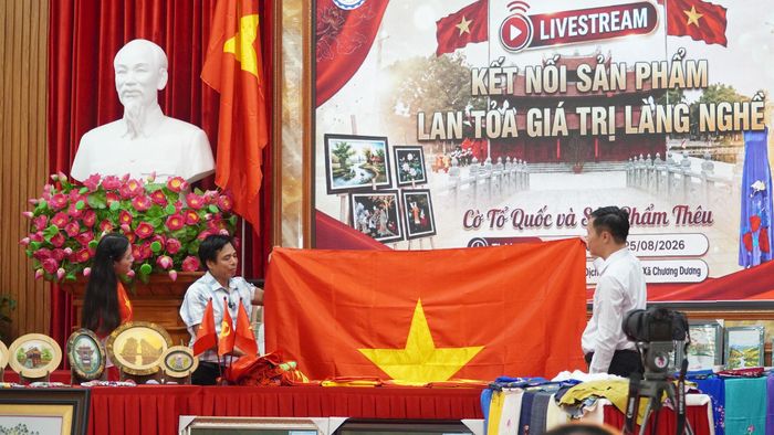 Ông Nguyễn Văn Phục (giữa), nghệ nhân làng nghề làm cờ Tổ Quốc chia sẻ những câu chuyện xung quanh những lá cờ tới khán giả. Ảnh: Duy Anh