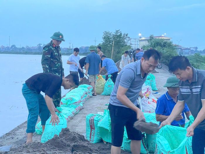 Lực lượng xung kích và nhân dân xã Trần Phú tham gia chống tràn đê Bùi 2 chiều tối 24-8. Ảnh: Hồng Đào