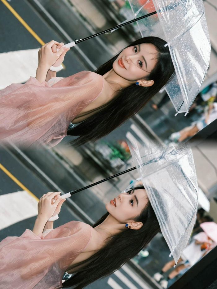 Điểm khiến nhiều người ấn tượng nhất vẫn là gương mặt rạng rỡ, lối trang điểm trong veo với lớp nền mỏng, son môi tông hồng nhẹ và mái tóc buông tự nhiên giúp người đẹp sinh năm 2002. Trong khung cảnh phố xá ướt mưa, những bức ảnh mang gam màu vintage càng làm nổi bật vẻ đẹp nữ tính, tạo cảm giác như một thước phim lãng mạn. 