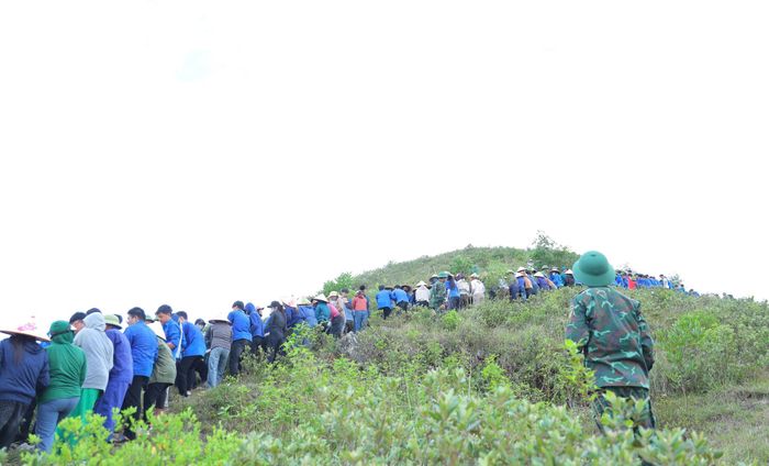 Hàng trăm cán bộ, chiến sĩ, đoàn viên và người dân Lam Thành chuyền từng tấm bê tông lên sườn núi Nhón để phục dựng dòng chữ "Bác Hồ sống mãi". Ảnh: Hà Huệ.