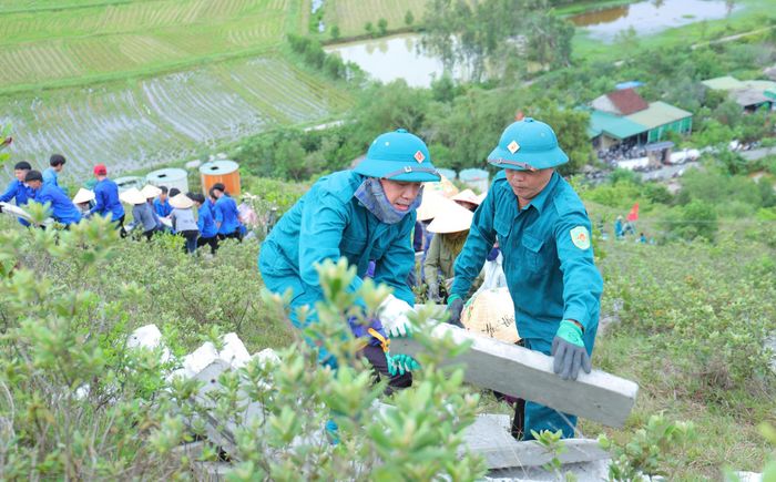 Người dân chia thành từng nhóm, luân phiên đưa vật liệu lên núi giữa những ngày nắng nóng. Ảnh: Hà Huệ.