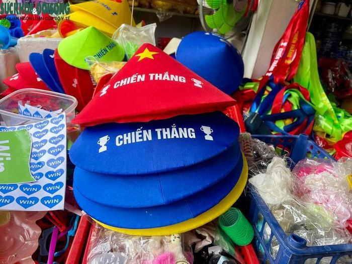 Người dân mua sắm áo quần, mũ nón, cờ có màu trùng với màu thuyền của đội nhà. Ảnh: Hùng Trần