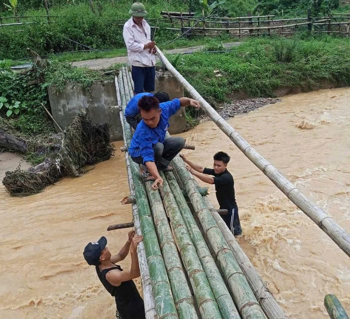 Lực lượng chức năng xã Nhôn Mai tận dụng tre, nứa làm cầu tạm vượt suối, giúp người dân bản Chà Lò đi lại (ảnh: CTV).