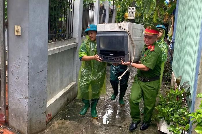 Chỉ huy và cán bộ, chiến sĩ Công an phường Sơn Tây hỗ trợ người dân di dời máy giặt cùng tài sản ra khỏi căn nhà bị ngập trong ngõ nhỏ.