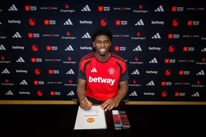 Baleba rạng rỡ trong ngày ký hợp đồng với MU. Ảnh: Manchester United.