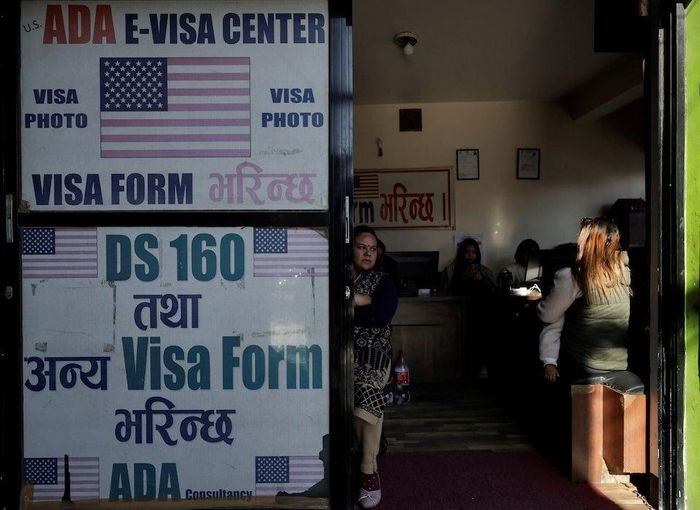  Khách hàng điền đơn xin visa Mỹ tại một công ty tư vấn hỗ trợ làm thủ tục visa ở Kathmandu, Nepal, ngày 28/11/2025. Ảnh: Reuters.