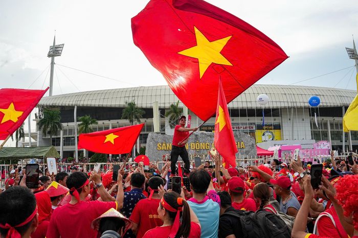 Trước giờ diễn ra trận chung kết lượt về ASEAN Cup 2026 giữa Việt Nam và Thái Lan, không khí tại khu vực quanh sân Mỹ Đình bắt đầu nóng lên. Hàng nghìn cổ động viên diện áo đỏ, mang theo cờ Tổ quốc và các vật dụng cổ vũ đổ về ngày một đông. Ảnh: Trần Hiền.