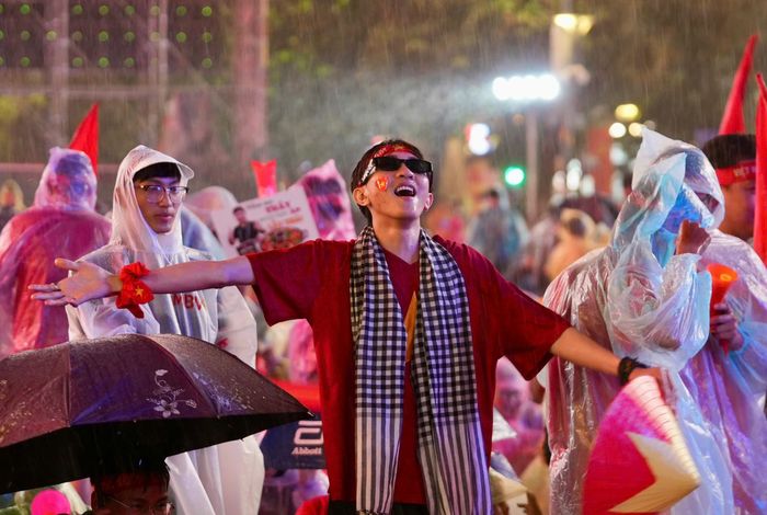  Ngô Việt Quang (21 tuổi) chia sẻ: "Cơn mưa này không làm giảm đi độ cuồng nhiệt của tôi và mọi người mà còn như tiếp sức thêm cho rất đông cổ động viên có mặt tại phố đi bộ Nguyễn Huệ hôm nay nữa". Anh dự đoán đội tuyển Việt Nam sẽ giành chiến thắng 3-0 trước Thái Lan. Ảnh: Quang Thông. 