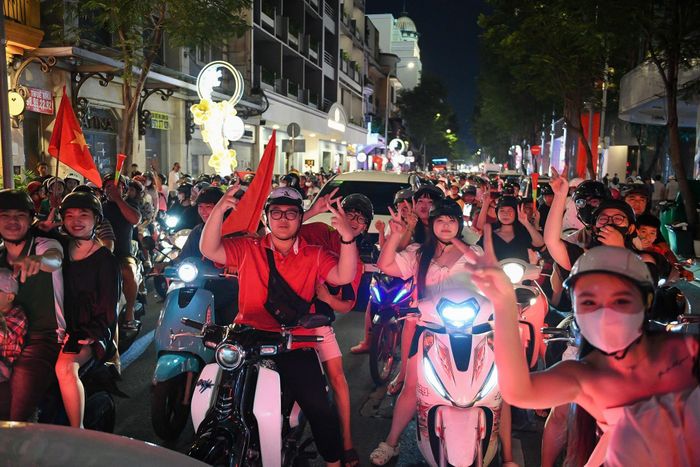  Dù phấn khích tột độ, đại đa số người dân xuống đường vẫn giữ tinh thần tự giác cao: đội mũ bảo hiểm đầy đủ, di chuyển trật tự và dừng xe chấp hành nghiêm túc tín hiệu đèn giao thông tại các giao lộ. Ảnh: Duy Hiệu. 