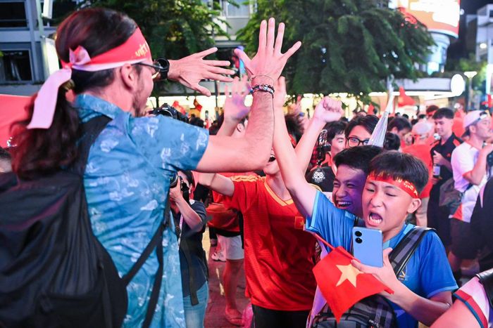  Không khí ăn mừng lan tỏa khắp nơi. Từ những nhóm bạn trẻ reo hò náo nhiệt, các cặp đôi ghi lại giây phút lịch sử, cho đến những gia đình hòa vào dòng người đông đúc. Nhiều du khách quốc tế cũng tỏ ra thích thú, liên tục dùng điện thoại ghi lại khoảnh khắc "có một không hai" và hòa chung niềm vui cùng người dân. Ảnh: Hoài Bảo. 