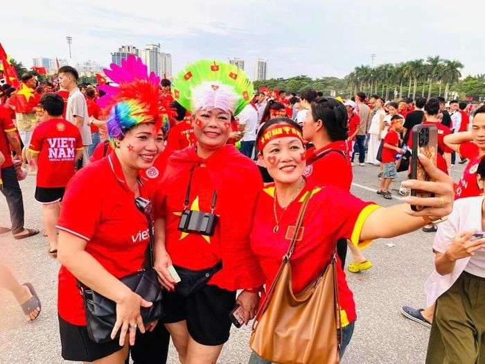 Người hâm mộ khoác trên mình áo cờ đỏ sao vàng lưu lại những bức hình kỷ niệm trước trận đầu. Ảnh: chinhphu.vn/Đỗ Long