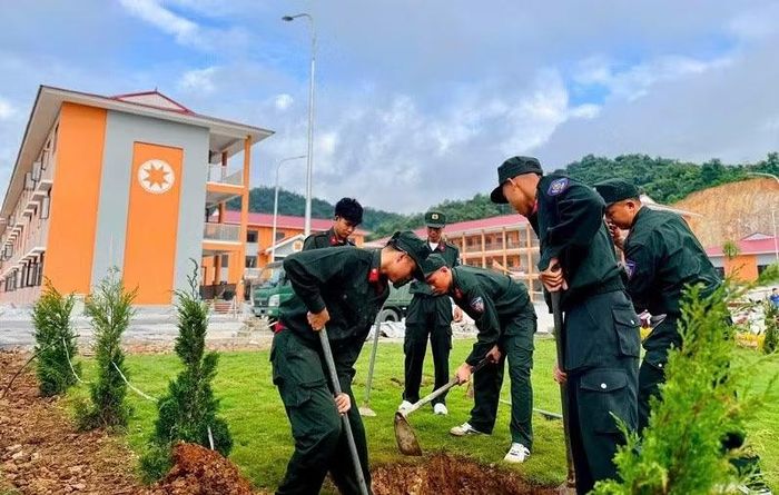 Chiến sĩ cảnh sát cơ động hỗ trợ trồng cây trong khuôn viên Trường nội trú liên cấp Thanh Nưa, tỉnh Điện Biên. (Ảnh: LÊ LAN)