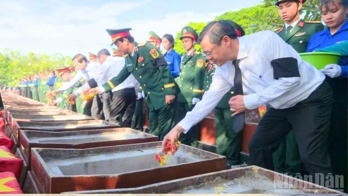 Lãnh đạo thành phố Cần Thơ thực hiện nghi thức an tang hài cốt liệt sĩ. (Ảnh: VĂN ÚT)