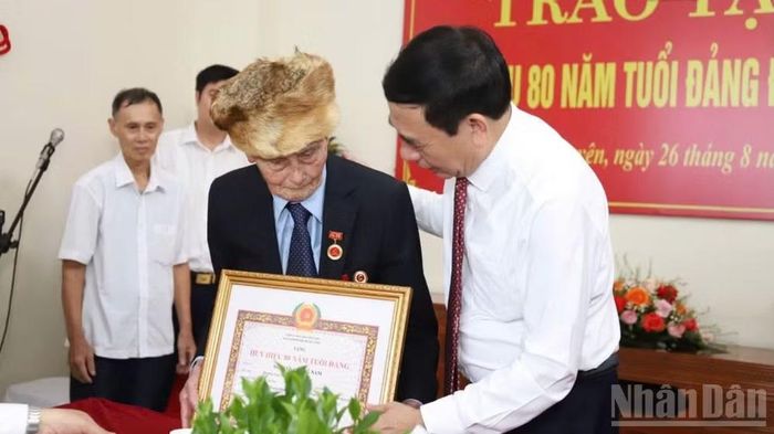Đại tướng Phan Văn Giang, Ủy viên Bộ Chính trị, Phó Thủ tướng Chính phủ, Bộ trưởng Quốc phòng trao Huy hiệu cho đảng viên lão thành Nguyễn Quang Nam. (Ảnh: DUY ĐỨC)