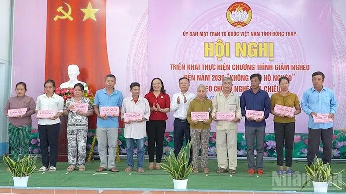Trao bảng tượng trưng hỗ trợ nhà ở và vốn sinh kế. (Ảnh: HỮU NGHĨA)