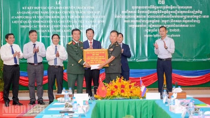 Thừa ủy quyền của Ban Chuyên trách Chính phủ Việt Nam, Đại tá Nguyễn Việt Thắng, Chính ủy Bộ Chỉ huy quân sự tỉnh An Giang, Phó trưởng Ban Chuyên trách tỉnh trao kinh phí hỗ trợ trị giá 20.000USD cho Ban Chuyên trách tỉnh Kép để phục vụ công tác tìm kiếm, quy tập trong mùa khô 2026-2027. (Ảnh: PHƯƠNG VŨ)