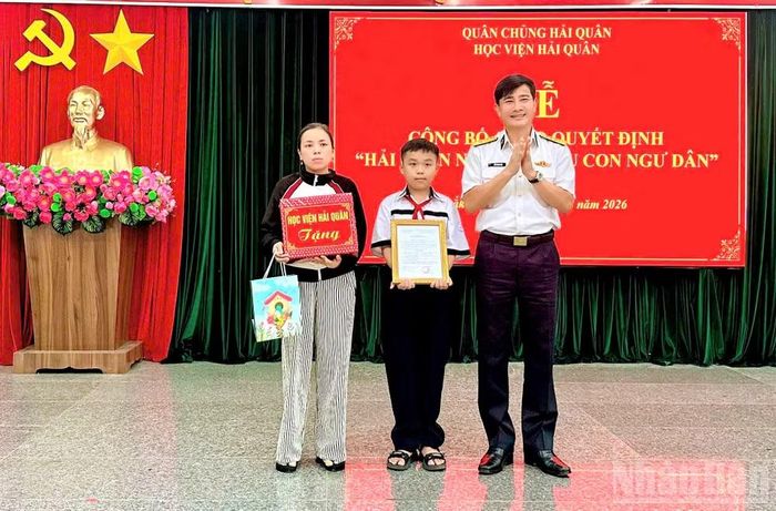 Đại tá Hồ Thanh Hòa, Phó Giám đốc Học viện trao quyết định và tặng quà cho gia đình cháu Trần Đoàn Tiến Thành.