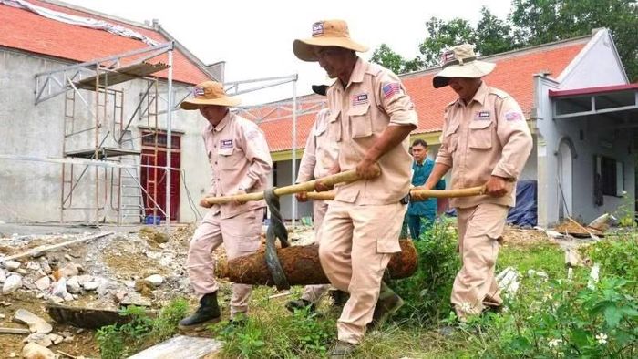 Đội xử lý bom mìn lưu động của Dự án MAG xử lý an toàn quả bom phát hiện trong khu dân cư ở xã Yên Hóa, huyện Minh Hóa, tỉnh Quảng Bình, nay là xã Minh Hóa, tỉnh Quảng Trị. (Ảnh: HƯƠNG GIANG)