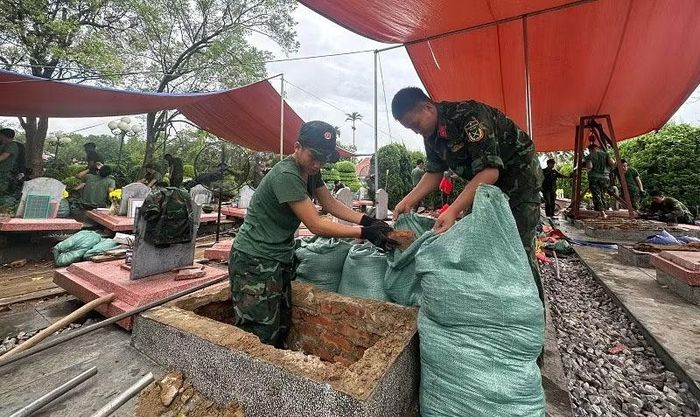 Chiến sĩ Bộ Chỉ huy Quân sự tỉnh Điện Biên thực hiện khai quật phục vụ lấy mẫu hài cốt liệt sĩ tại Nghĩa trang liệt sĩ Độc Lập. (Ảnh: LÊ LAN)